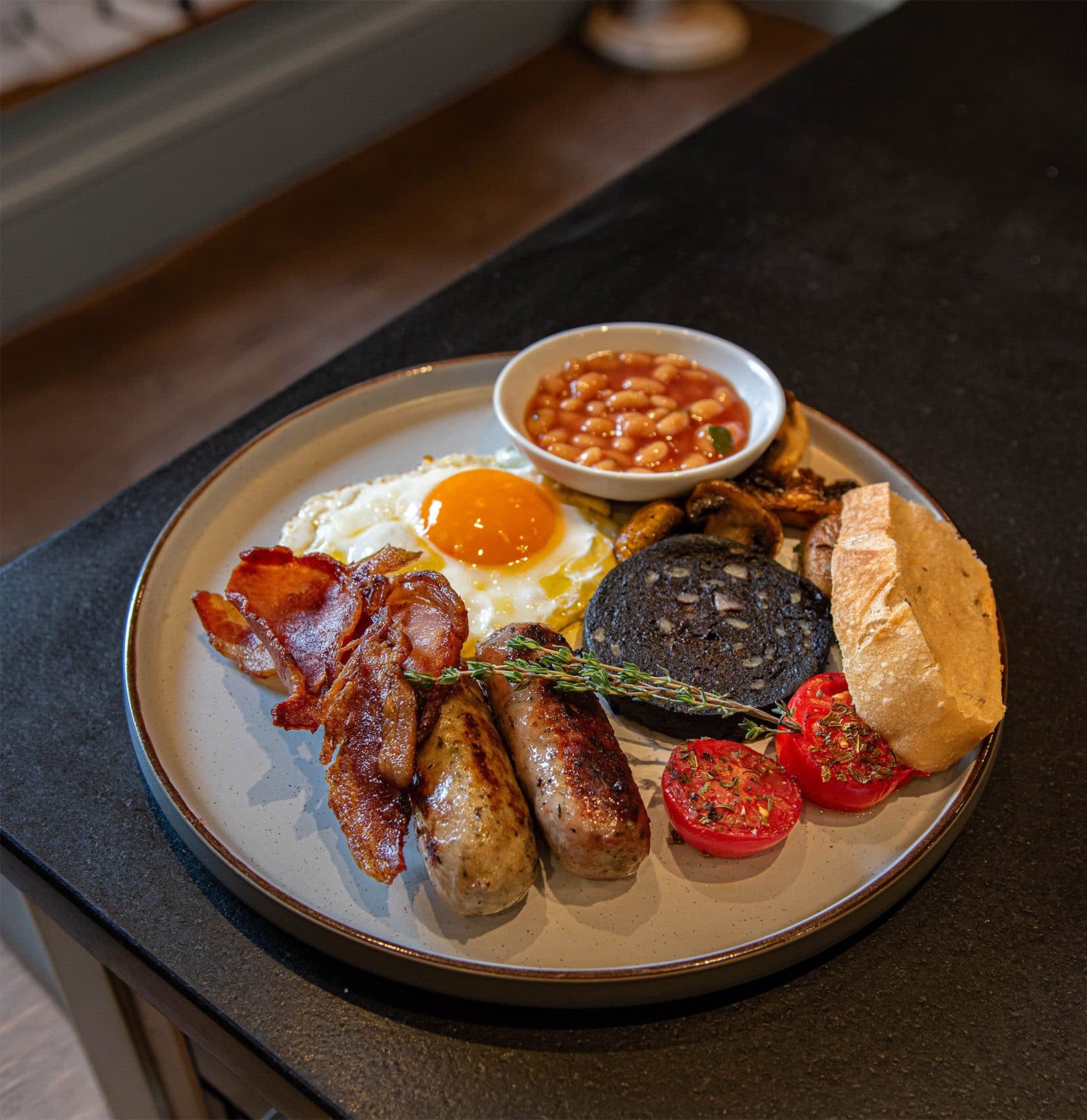 A full English breakfast: bacon, sausages, fried egg, black pudding, roast tomatoes, mushrooms and a pot of baked beans